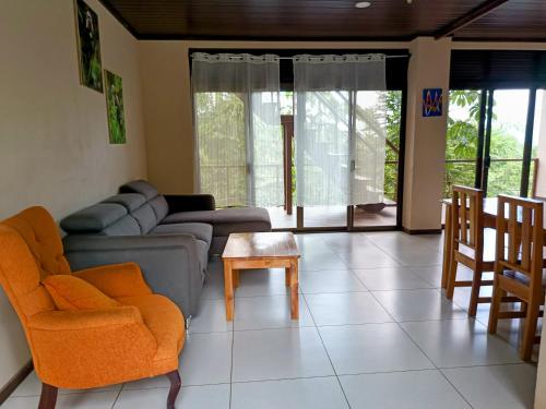 a living room with a couch and chairs and a table at Eco Villas-Houses-Tents Corcovado-Mountain-Ocean Views in Puerto Jiménez