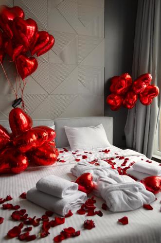 a bed with red roses and towels and hearts at SkySpa Apartments - апартаменти з джакузі на терасі з видом на Печерськ in Kyiv