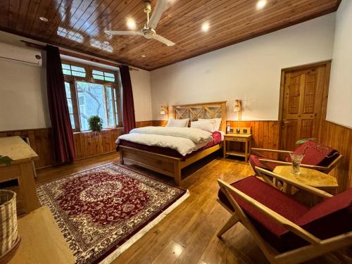 a bedroom with a bed and a couch and a table at The Pecan Resort in Gilgit