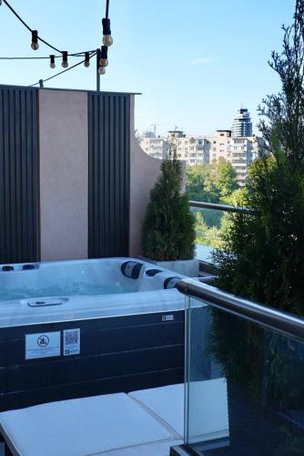 a hot tub on a balcony with a view of a city at SkySpa Apartments - апартаменти з джакузі на терасі з видом на Печерськ in Kyiv