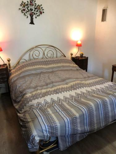 - un lit dans une chambre avec 2 lampes sur 2 tables dans l'établissement Gite équestre, belle maison ancienne en pierre, à Saint-Setiers