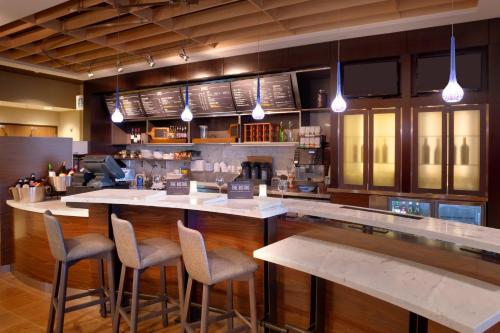 a kitchen with a bar with bar stools at Courtyard by Marriott Phoenix Mesa Gateway Airport in Mesa
