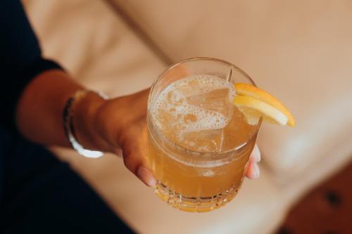 a person holding a drink with an orange slice on it at The Ritz-Carlton, Berlin in Berlin
