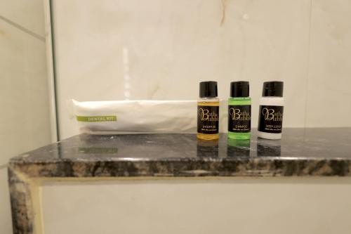 three bottles of essential oils sitting on a counter at Hotel Shrinath Palace in Mathura