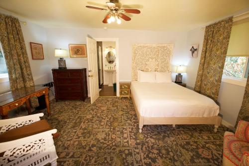 a bedroom with a bed and a ceiling fan at Yosemite Bug Rustic Mountain Resort in Midpines