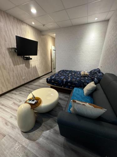 a room with a couch and a bed and a tv at 淡水遇見民宿Meet Homestay in Tamsui