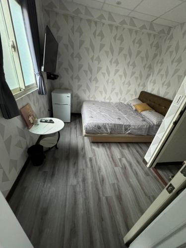 a small bedroom with a bed and a table at 淡水遇見民宿Meet Homestay in Tamsui