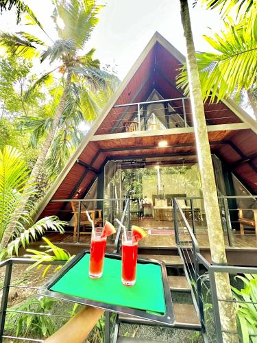 two drinks on a table in front of a house at Rustic Cottages Udawalawe in Udawalawe