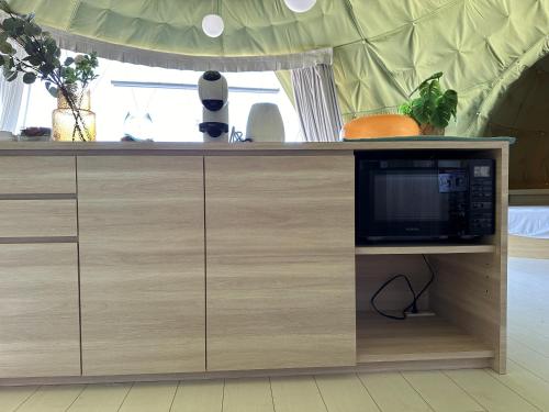 a cabinet with a microwave on top of it at グランピングカシマ753 in Kashima