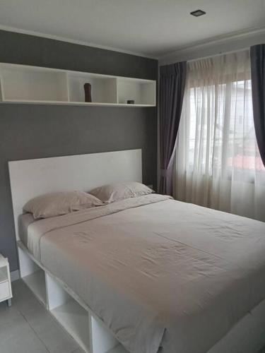 a white bed in a bedroom with a window at Large Corner Apartment 1BR - NV-207 in Ban Klang