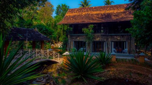a house with a bridge in front of it at Beyond Eco Living in Munnar