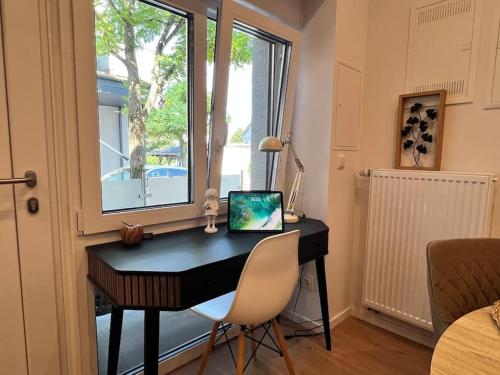 a desk with a laptop on it in front of a window at Saalburg Apartment in Neu-Anspach
