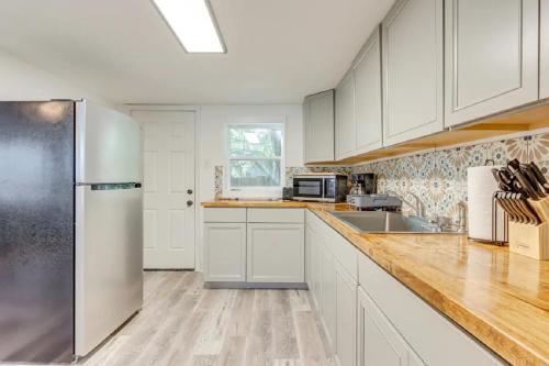 a kitchen with white cabinets and a stainless steel refrigerator at Mid-Town Cave for 6 Guests 3 Bedroom 1 Bath in Mobile