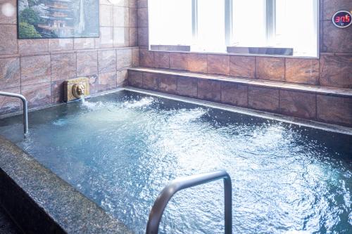 a large pool of water in a room with windows at Hotel New Palace in Shingu