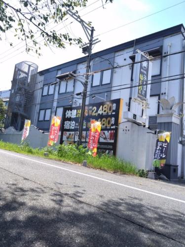 a building with signs on the side of a street at HotelおとぼけビーバーPREMIUM in Himeji