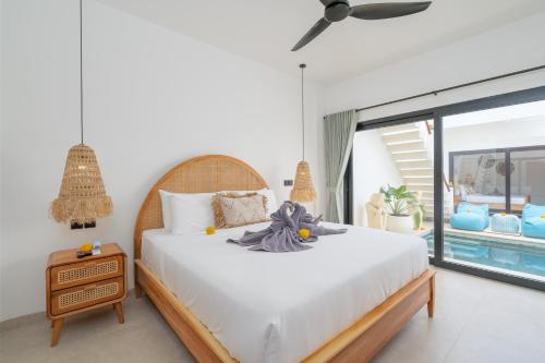 a bedroom with a large white bed and a window at Villa Sawahku - 2 Bedrooms Private Villa with Rooftop and View in Canggu
