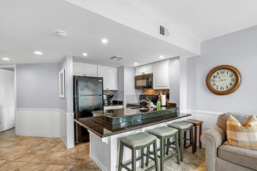 a kitchen with a bar and a clock on the wall at Plantation West Condos in Gulf Highlands