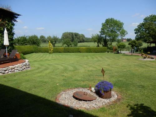 a garden with a bench and flowers in the grass at No 3 - Krautsand Comfortable Vacation Home in Krautsand