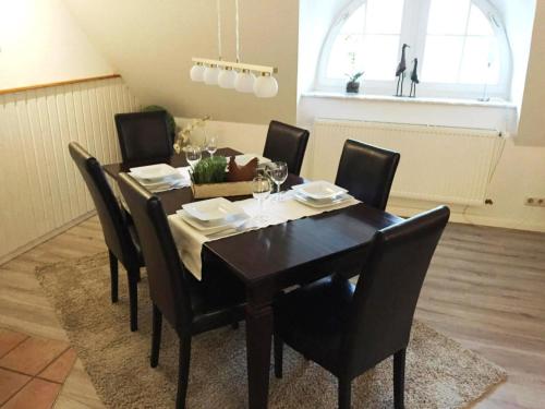 a dining room with a table with black chairs at No 3 - Krautsand Comfortable Vacation Home in Krautsand