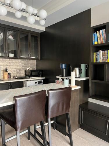 a kitchen with black cabinets and a table and chairs at Private Rooms in Vancouver West in Vancouver