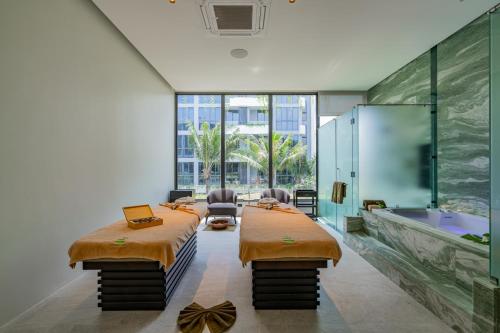 a large room with two beds and a bath tub at La Green Hotel and Residence in Bang Tao Beach