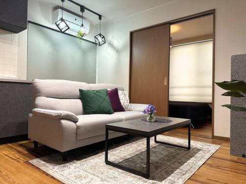a living room with a couch and a table at SapporoCity Ark Coat 203 in Minami-jūichijō