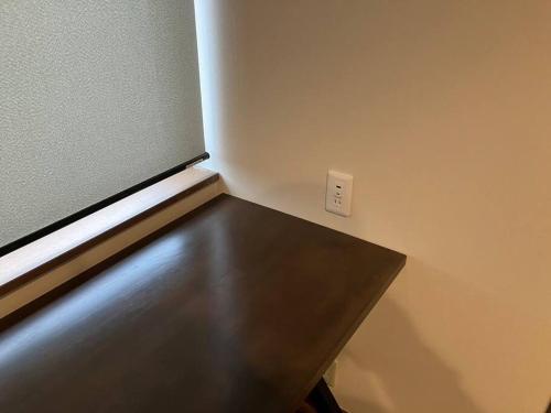 a black table in a room with a wall with a lightswitch at SapporoCity Ark Coat 203 in Minami-jūichijō