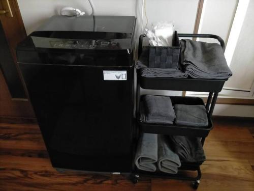 a black shelf with clothes and shoes on it at SapporoCity Ark Coat 203 in Minami-jūichijō