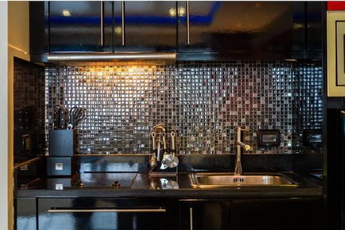 eine Küche mit einer Spüle und einem Fliesen-Rückenspritzer in der Unterkunft Studio Apartment in Bangla Rd in Patong Beach