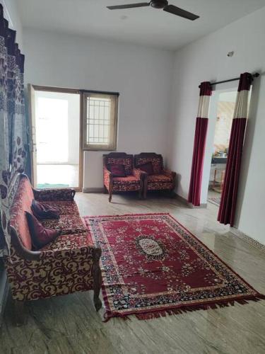 a living room with a couch and a rug at MMVK Homestay AC, Spacious & Comfortable Entire Home Just For You in Pollāchi