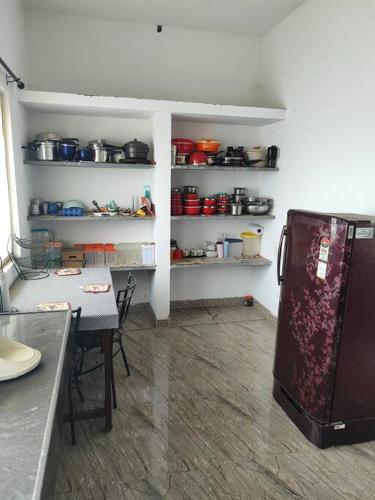 a kitchen with a table and a refrigerator in a room at MMVK Homestay AC, Spacious & Comfortable Entire Home Just For You in Pollāchi