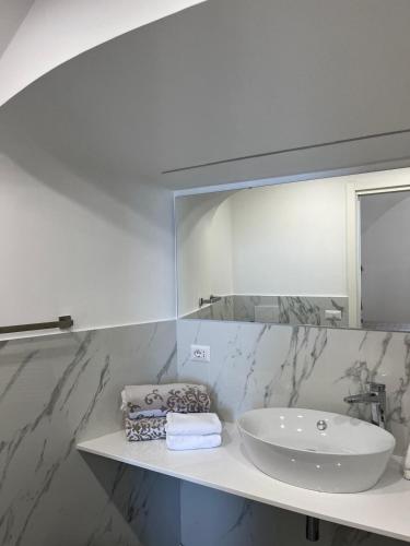 a white bathroom with a sink and a mirror at Agriturismo Il Convento in Massa Lubrense