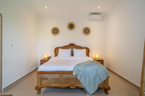 a bedroom with a bed and two clocks on the wall at Villa Margherita 3 Bedroom Canggu Swimming Pool in Canggu