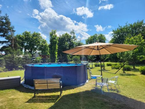 an umbrella and two chairs and a pool at Apartmán v podzámčí in Rychnov nad Kněžnou