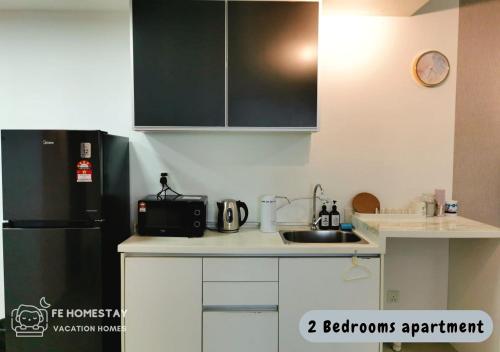 a kitchen with a black refrigerator and a sink at Netflix WiFi Cozy Homestay Trefoil Setia Alam Shah Alam 沙亚南舒适温馨日租民宿 in Setia Alam