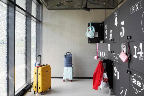 a room with luggage and bags on a wall at Moxy Cologne Bonn Airport in Cologne