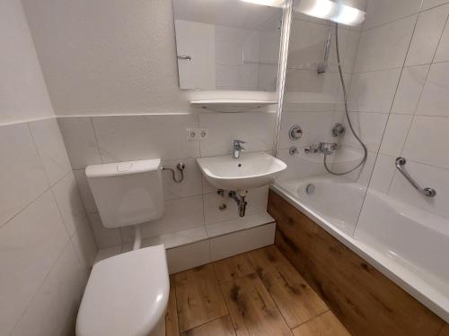 a bathroom with a toilet and a sink and a tub at Appartement Arend in Dobel