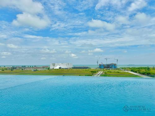 a large body of blue water with a cloudy sky at Amber Cove Melaka Sea View by Stayrene in Melaka