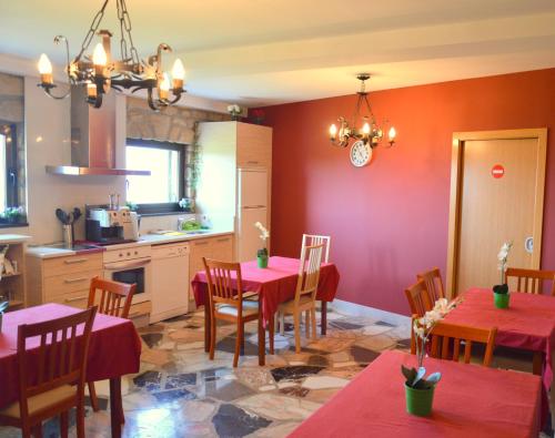 a kitchen and dining room with red walls and tables at Iturritxo Landetxea in Donostia-San Sebastián