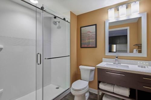 a bathroom with a shower and a toilet and a sink at TownePlace Suites by Marriott Columbus North - OSU in Columbus