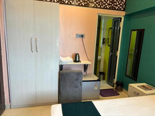 a bedroom with a bed and a desk and a door at Bhadra Kali Guest House in Varanasi