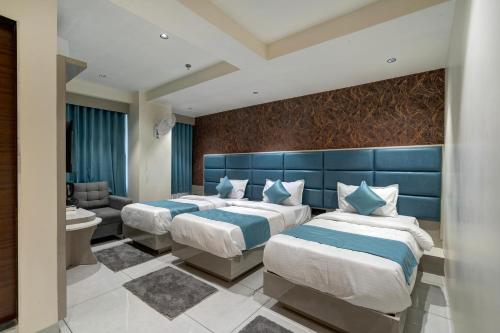 a hotel room with two beds and a bathroom at Hotel Shrimad Villa Gandhinagar in Gandhinagar