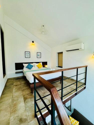 a bedroom with a bed and a staircase at HALF Hotel, Calangute in Calangute