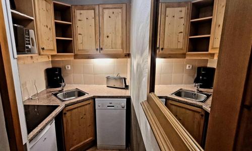 une petite cuisine avec des placards en bois et 2 lavabos dans l'établissement Résidence Les Valerianes - Appartement 6 personnes place centrale les orres 1800 MAE-4601, aux Orres