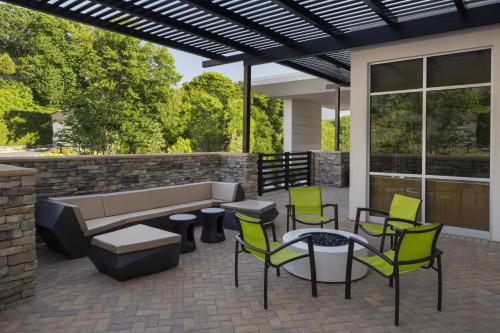 a patio with a couch and chairs and a table at SpringHill Suites by Marriott Tuckahoe Westchester County in Tuckahoe