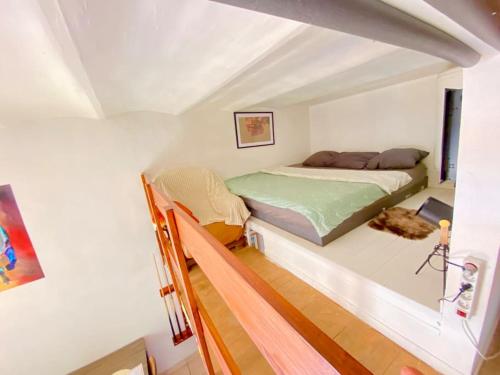 une petite chambre avec un lit dans un grenier dans l'établissement Appart Vintage & son Billard, 300m de la Gare !, à Nîmes