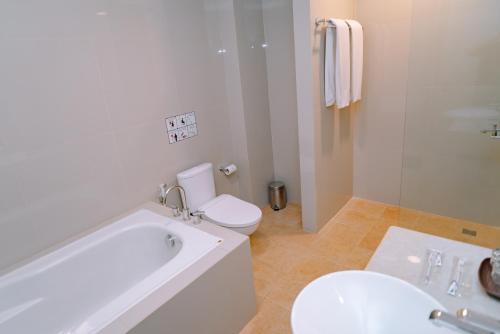 a bathroom with a tub and a toilet and a sink at Sahid Bandara Soekarno Hatta in Tangerang