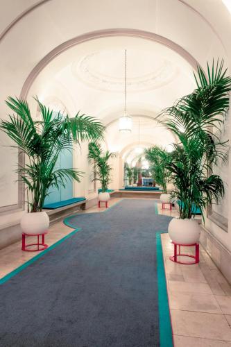 a hallway with palm trees in a building at Mercure Lyon Centre Château Perrache in Lyon