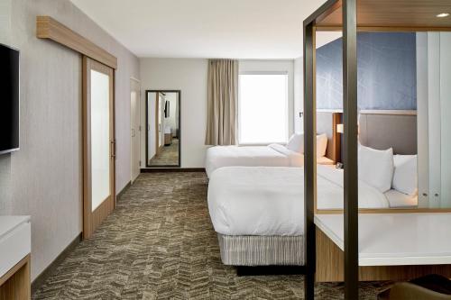 a hotel room with two beds and a mirror at SpringHill Suites by Marriott Columbus Dublin in Dublin