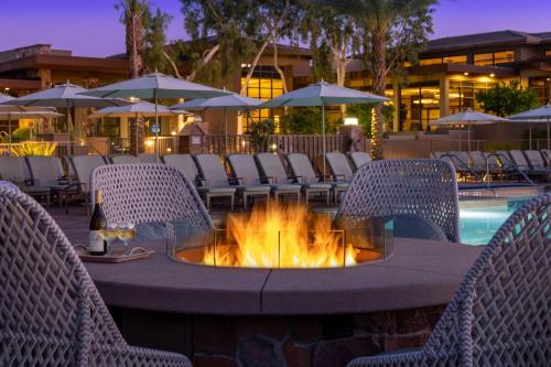 a fire pit in a patio with chairs and a pool at The Westin Desert Willow Villas, Palm Desert in Palm Desert